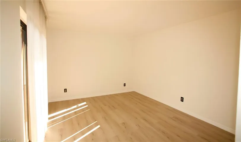 Bright interior space featuring light-toned wood-finish flooring and white baseboards