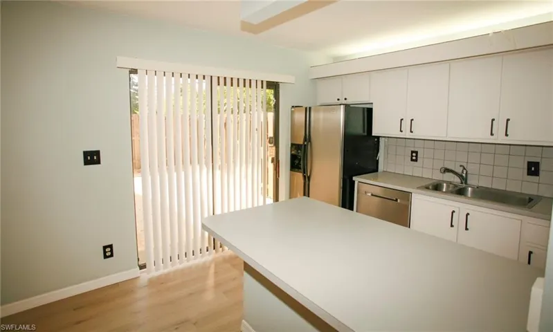 Kitchen featuring white cabinetry, light countertops, and a stainless steel refrigerator