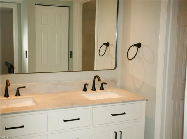 Dual vanity with white cabinetry and dark hardware
