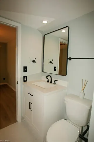Bathroom featuring a white vanity with an undermount sink, a light-toned countertop, and matte black fixtures