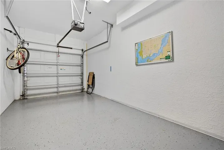 Garage featuring a garage door opener and a textured wall
