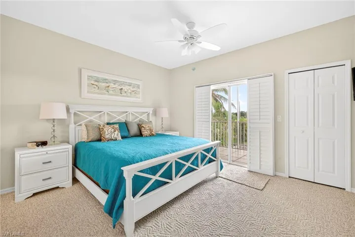 Bedroom featuring access to outside, light colored carpet, ceiling fan, and a closet