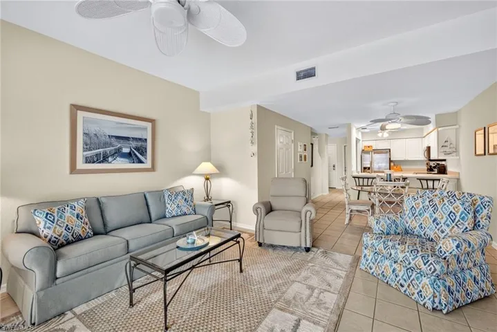 Living area with a ceiling fan and light tile patterned flooring
