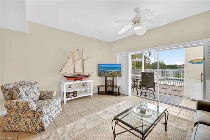 Living room featuring light tile patterned floors and a ceiling fan