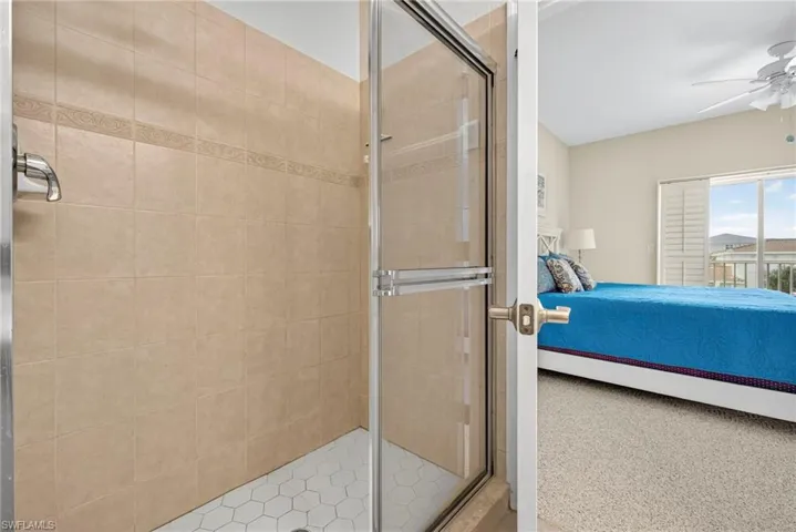 Full bathroom with ensuite bathroom, a stall shower, and a ceiling fan