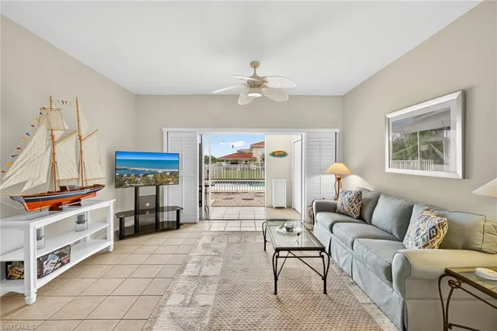 Living room featuring light tile patterned floors and a ceiling fan