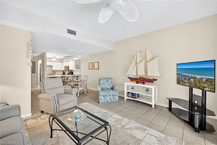 Living room featuring light tile patterned floors and ceiling fan