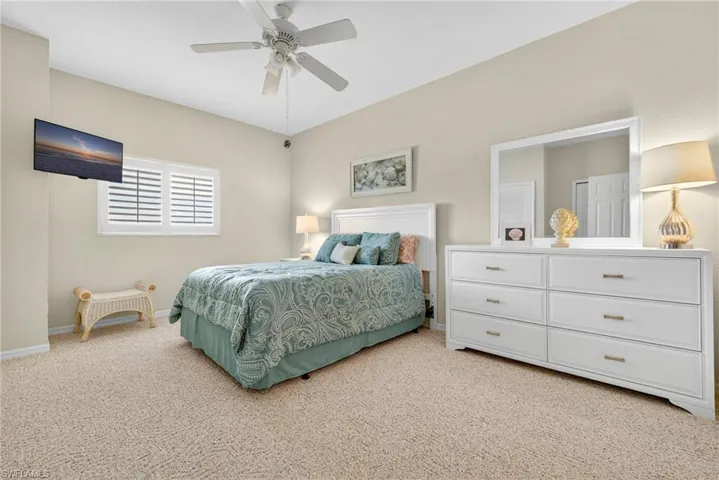 Bedroom featuring light carpet and a ceiling fan