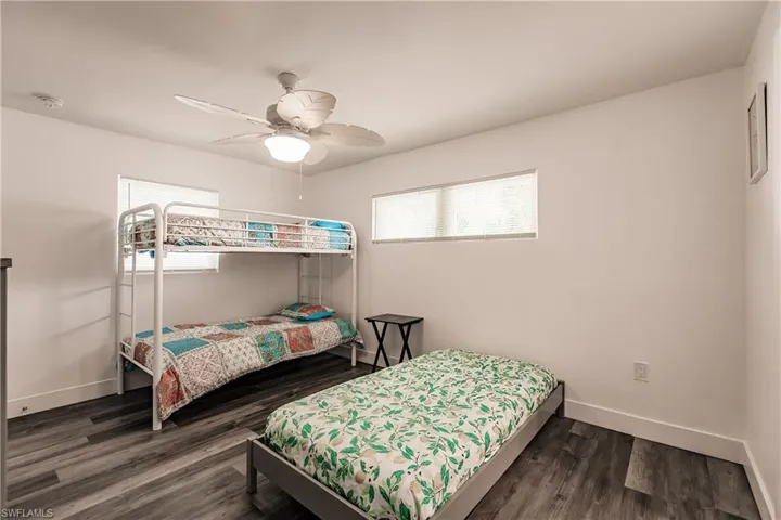Bedroom with dark wood-style flooring and a ceiling fan