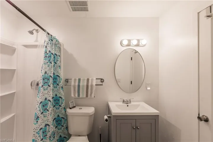 Bathroom with a shower with curtain and vanity