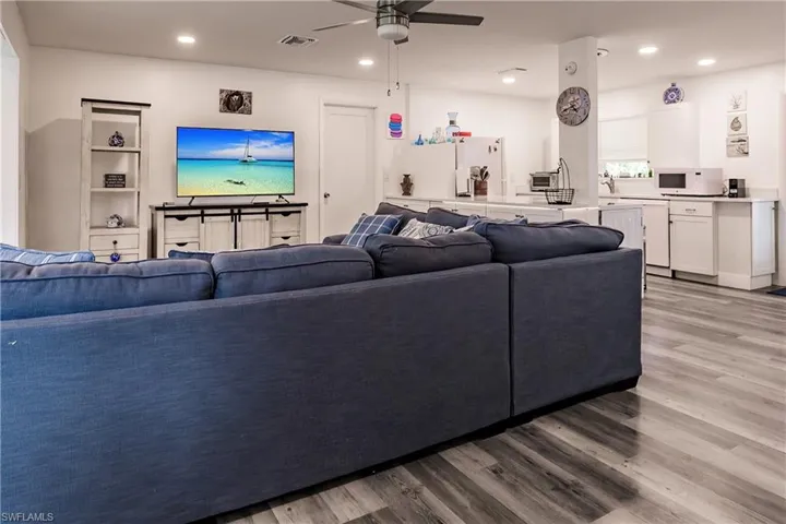 Living area featuring a ceiling fan, light wood finished floors, and recessed lighting