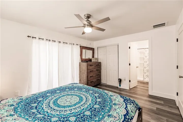 Bedroom featuring dark wood finished floors, a ceiling fan, and a closet