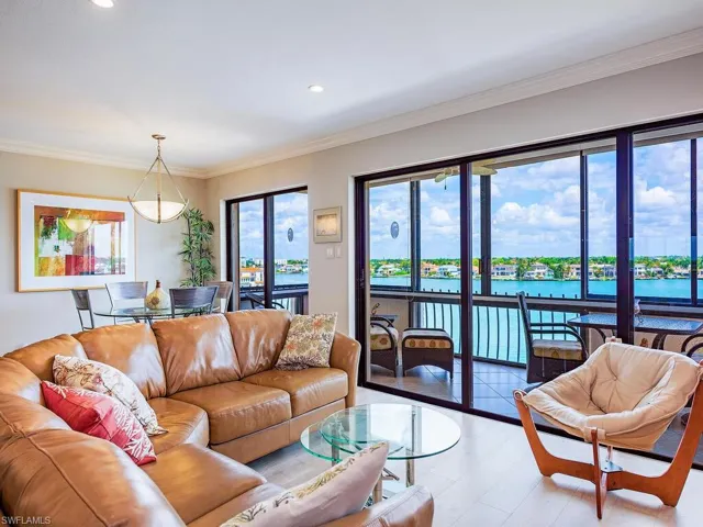 Living area with a water view, crown molding, and recessed lighting