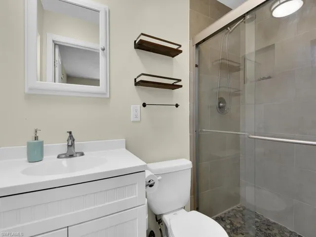 Bathroom with an enclosed shower, vanity, and toilet