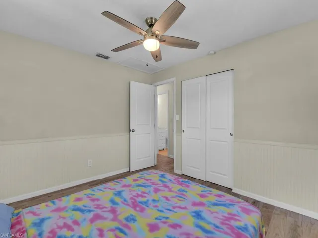 Bedroom with hardwood / wood-style flooring, a closet, and ceiling fan