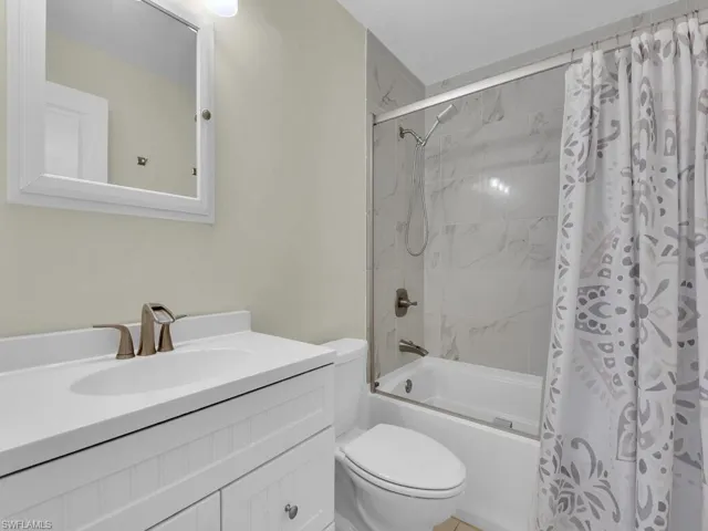 Full bathroom with shower / bath combination with curtain, toilet, and vanity