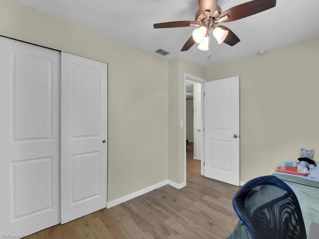 Unfurnished bedroom with a closet, ceiling fan, and light wood-type flooring