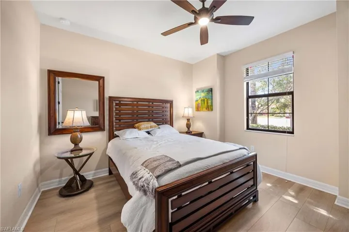 Bedroom with light wood finished floors, baseboards, and ceiling fan