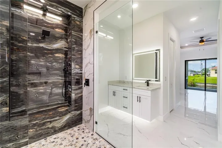 Primary Bathroom spacious walk-in shower with 3-spray system and sitting area.