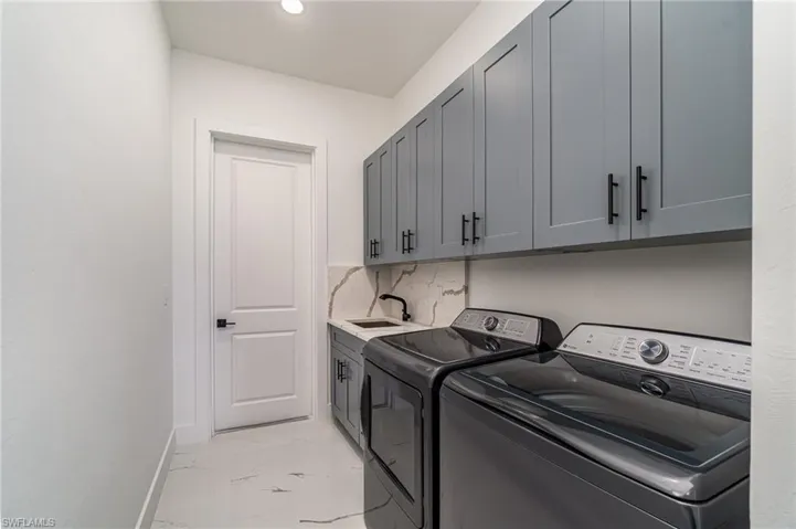 Laundry room with 42" cabinets, independent washer and dryer, and sink.
