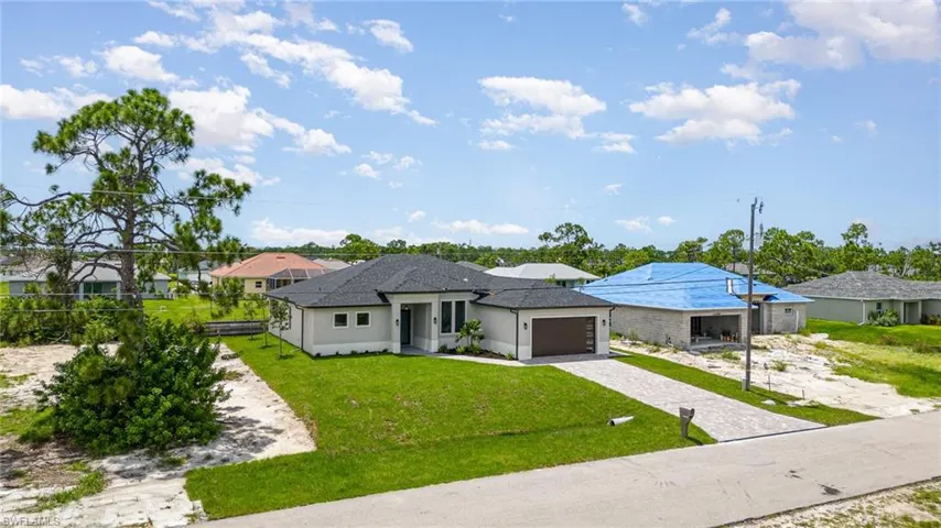 View of front of property featuring a garage and a front yard
