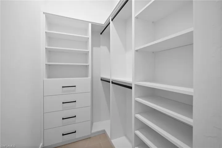 Walk in closet with light tile patterned floors