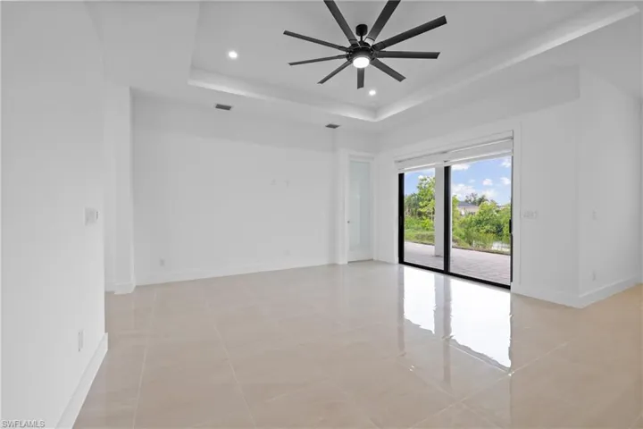 Unfurnished room featuring light tile patterned floors, a tray ceiling, recessed lighting, and baseboards