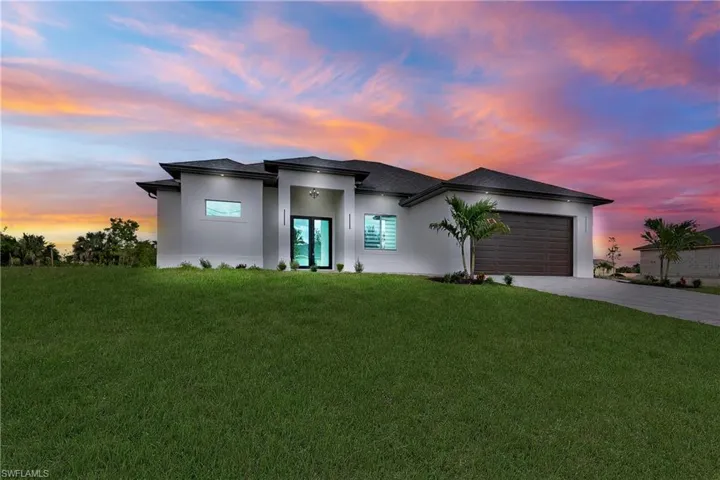 View of front of property featuring driveway, stucco siding, an attached garage, a front lawn, and a shingled roof