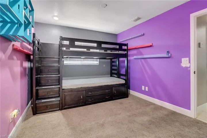 Carpeted bedroom featuring visible vents and baseboards