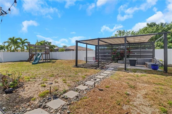 View of yard featuring a fenced backyard and a playground