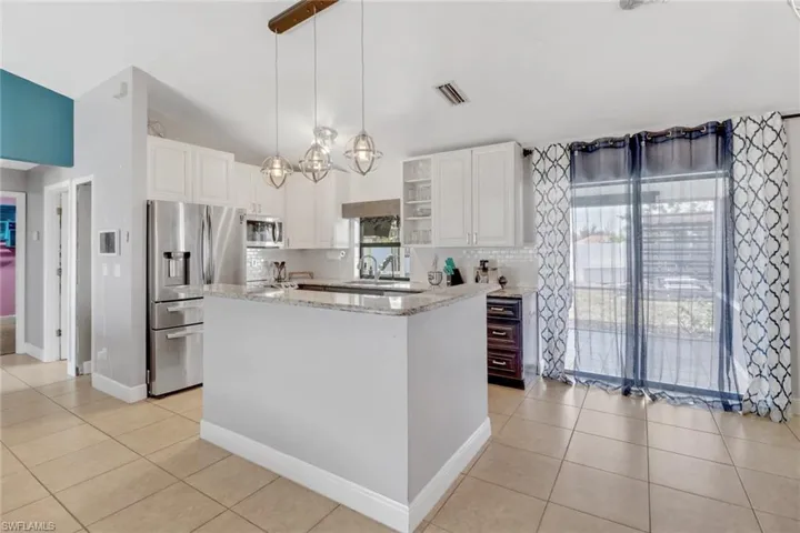 Kitchen featuring white cabinetry, visible vents, pendant lighting, and stainless steel appliances