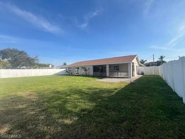 Back of property with a patio area, a fenced backyard, and a lawn
