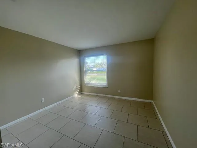 Unfurnished room with baseboards and light tile patterned floors