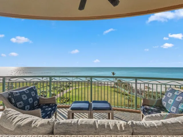 Balcony with a view of the beach, a water view, and ceiling fan
