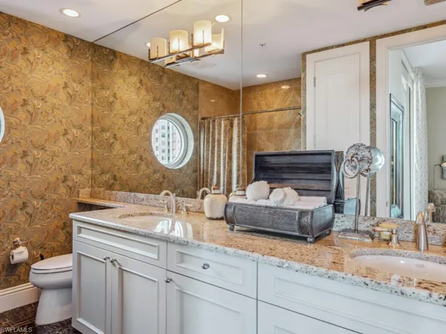 Bathroom featuring a shower with shower curtain, vanity, and toilet