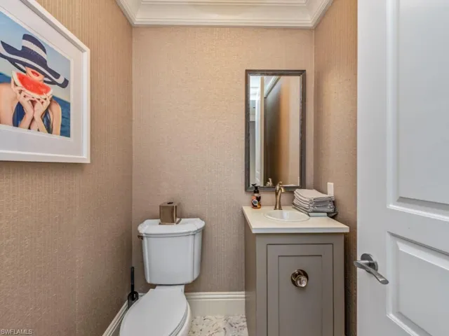 Bathroom with vanity, toilet, and crown molding