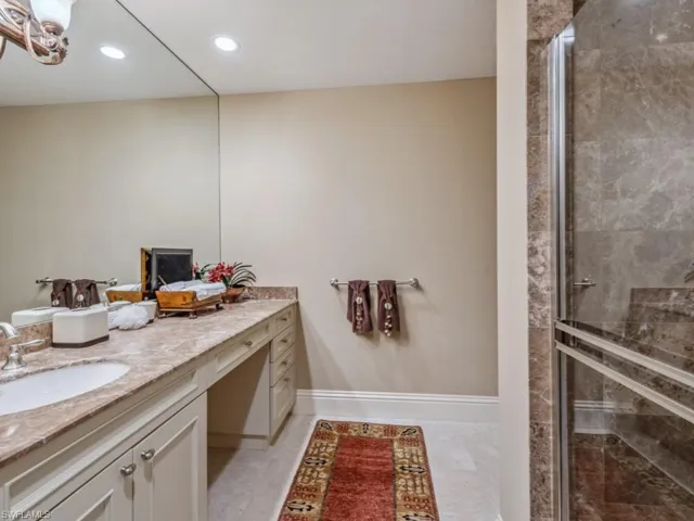Bathroom with a shower with door, vanity, and tile patterned flooring