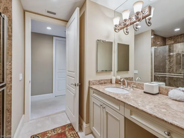 Bathroom featuring tile patterned floors, vanity, and walk in shower