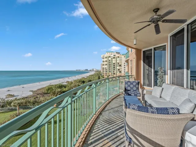 Balcony with ceiling fan, a water view, and a view of the beach
