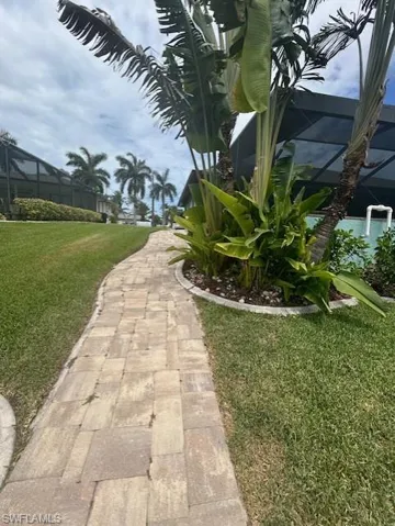 Brick Pavered Walkway alongside side of home leads to Canal & Dock