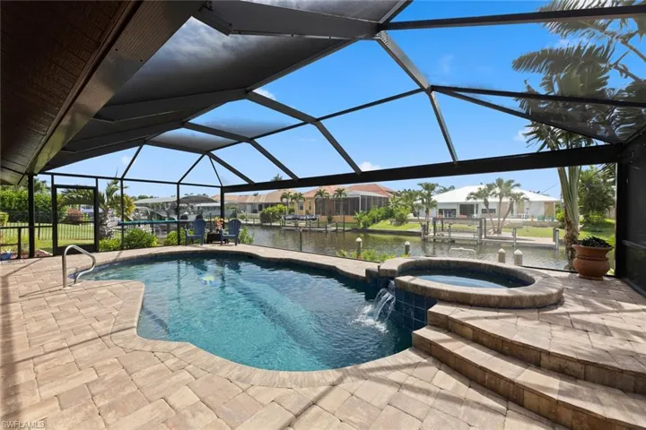 View of free form pool, spa. Panoramic screen on cage provides uninterrupted waterviews