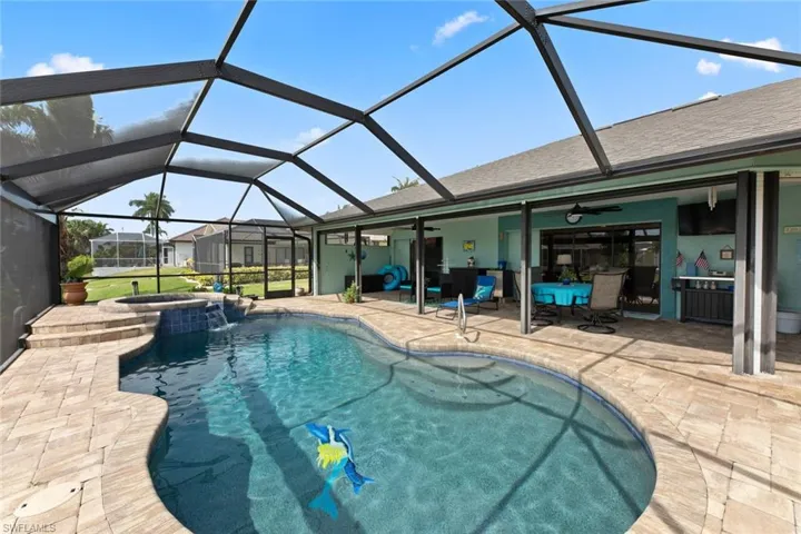 Heated pool with pebble tech finish and attached spa with inlaid dolphins & colorful mermaid