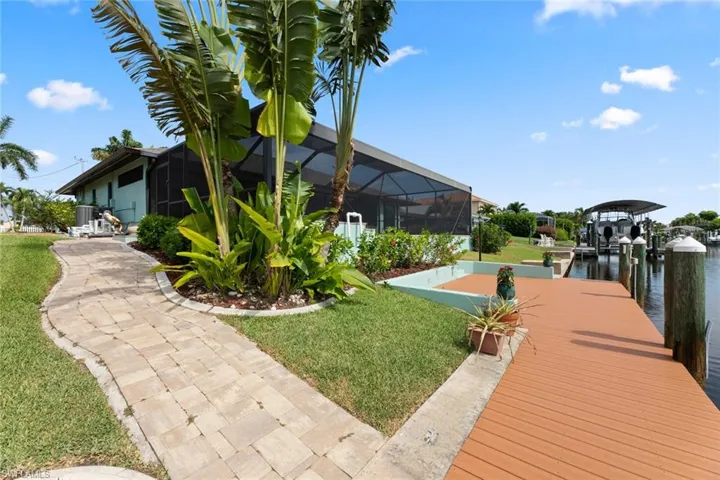 Dock area featuring a yard, glass enclosure, and a water view