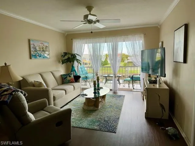 Living room with ceiling fan, ornamental molding, and wood finished floors