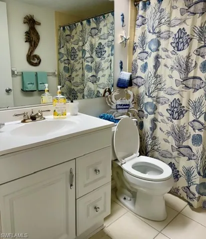 Bathroom featuring a shower with curtain, vanity, and light tile patterned floors