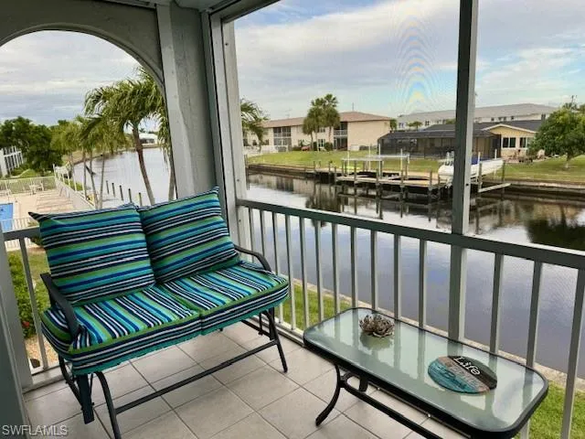Balcony featuring a sunroom, a water view, and a residential view