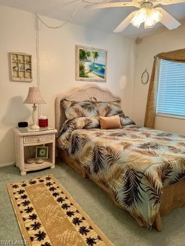 Carpeted bedroom with a ceiling fan