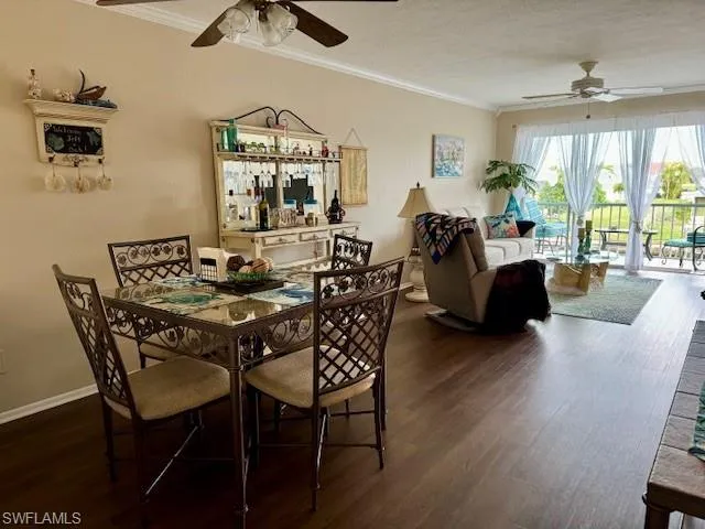 Dining area with ceiling fan, wood finished floors, crown molding, and a textured ceiling