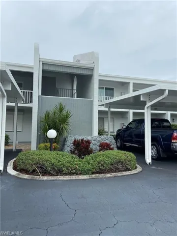 View of side of home with a balcony and covered parking