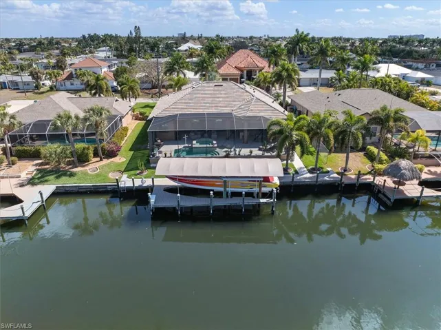 Dock featuring glass enclosure, a pool, a water view, a residential view, and boat lift